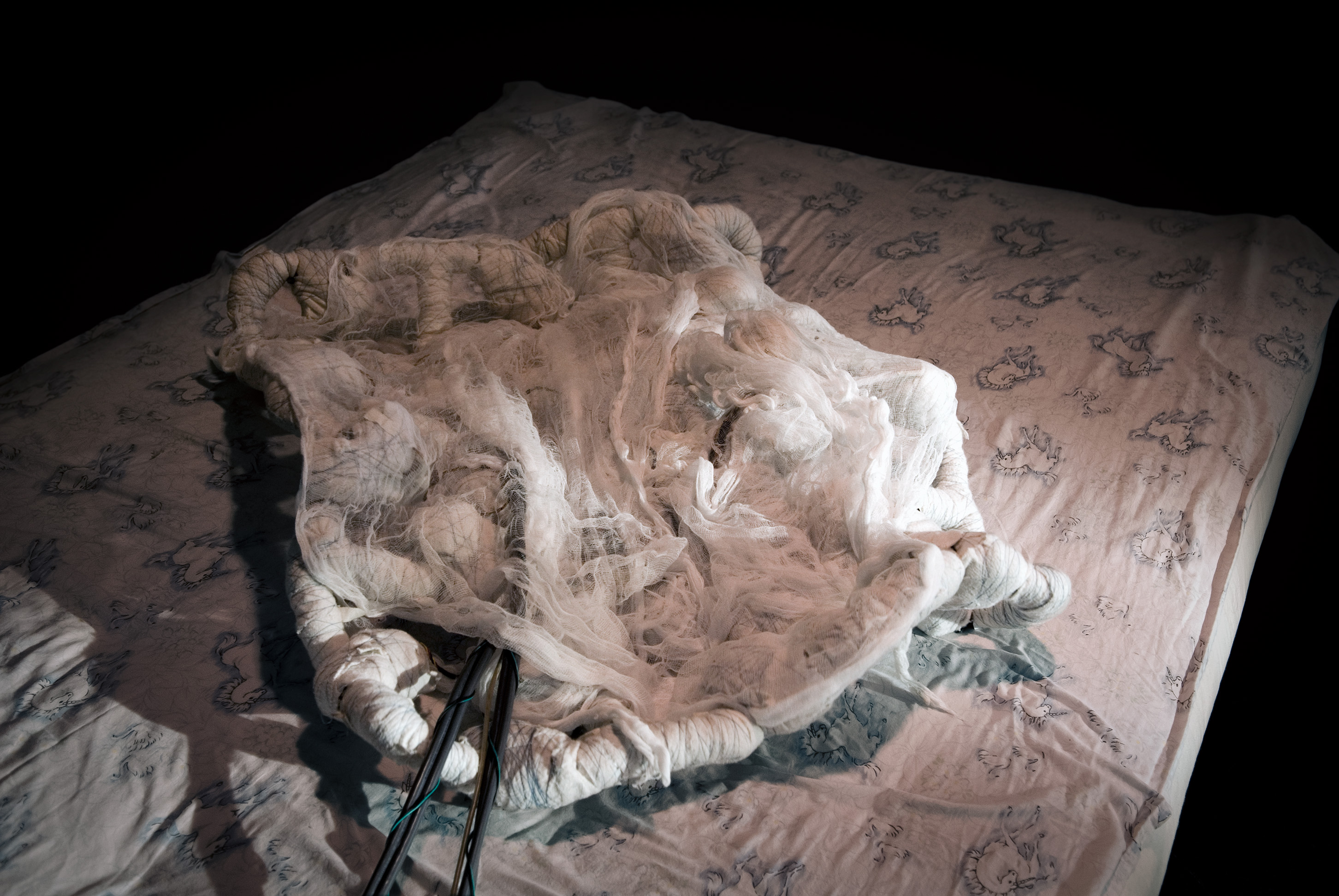 The Blanket robotic sculpture resting on a bed